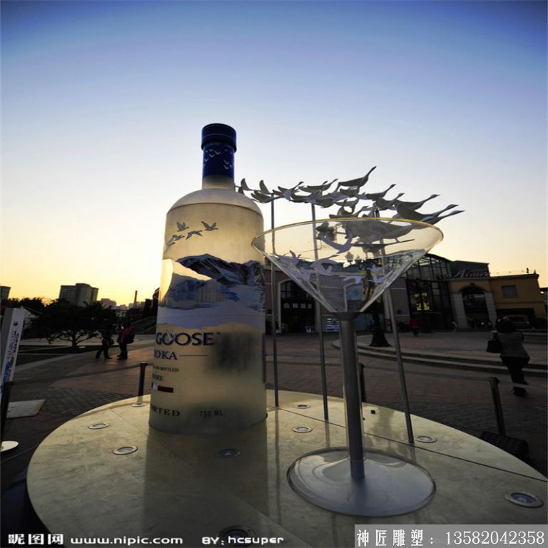 夕阳下酒杯与酒瓶雕塑图片